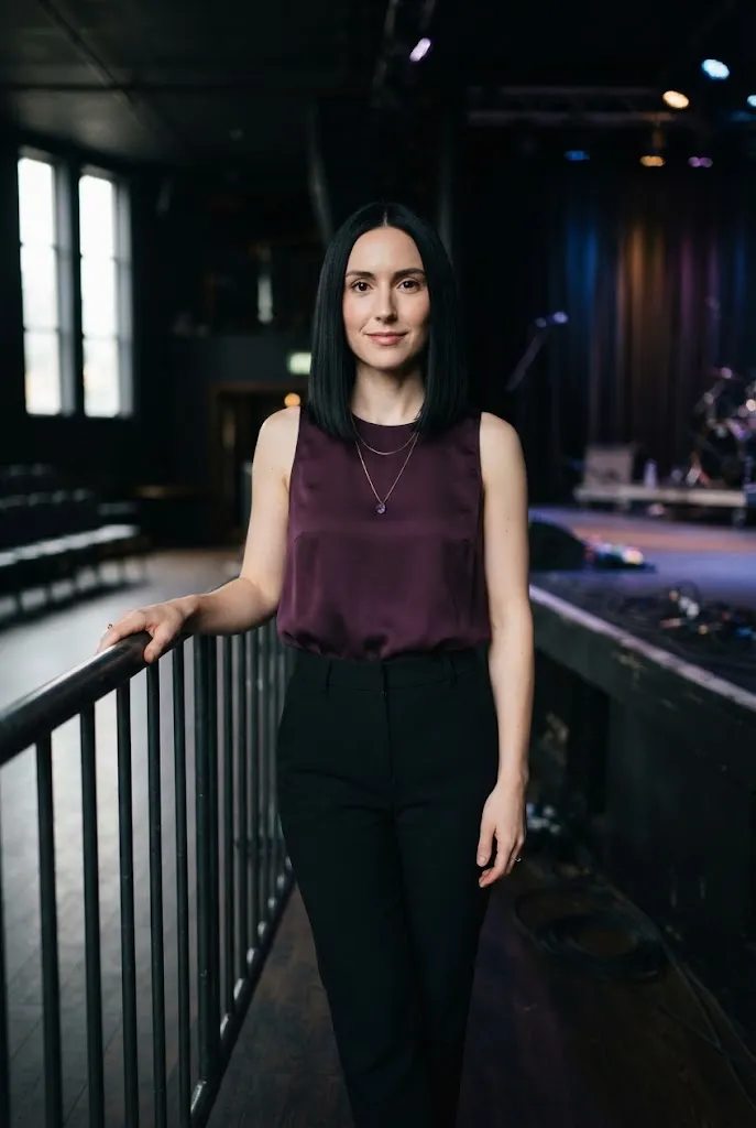 Woman wearing a deep plum top styled with neutral pieces for a concert