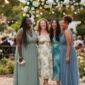 Four plus size women in colorful aesthetic wedding guest outfits standing together in a garden venue